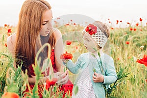 Mother and daughter in beautiful poppy field