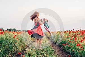 Mother and daughter in beautiful poppy field