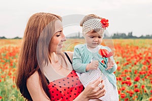 Mother and daughter in beautiful poppy field