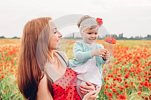 Mother and daughter in beautiful poppy field