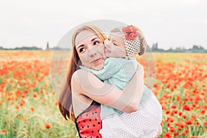 Mother and daughter in beautiful poppy field