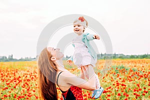 Mother and daughter in beautiful poppy field