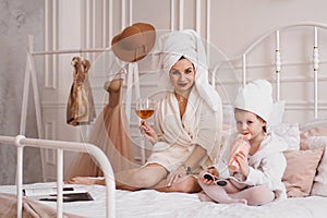 Mother and daughter in the bedroom in bathrobes