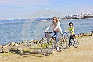 Mother and Daughter biking along the beach in San Francisco