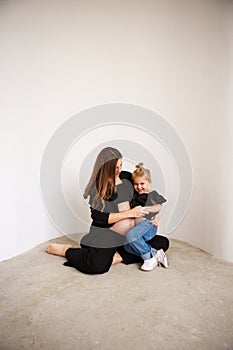 Mother and daughter in black outfits hug each other. Mothers Day.