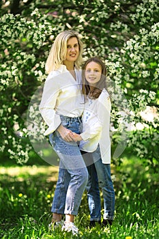 Mother and daughter in the blooming rose gardens of Apple trees. Happy motherhood. Beautiful family portrait