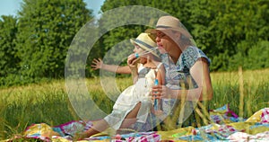 Mother and daughter blow soap bubbles in the park.