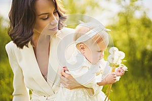 Mother and daughter blowing to dandelion