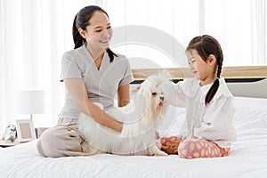 Mother and daughter brushing dog fur.