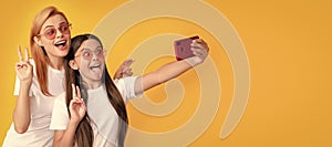 Mother and daughter child banner, copy space,  background. happy woman and girl take selfie with smartphone