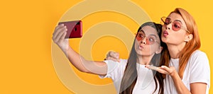 Mother and daughter child banner, copy space, isolated background. happy woman and girl take selfie with smartphone