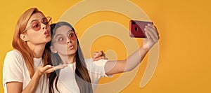 Mother and daughter child banner, copy space, isolated background. happy woman and girl take selfie with smartphone