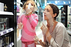 Mother and daughter choose perfume in perfume shop