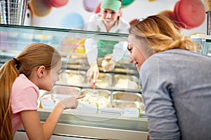 Mother and daughter chooses ice cream in confectionery