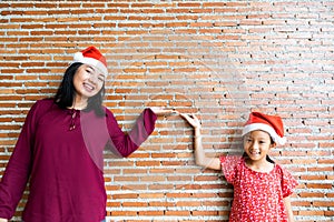 Mother and daughter in Christmas Santa Clause hat with blan
