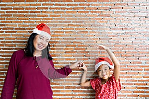 Mother and daughter in Christmas Santa Clause hat with blan