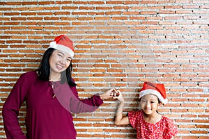 Mother and daughter in Christmas Santa Clause hat with blan
