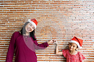 Mother and daughter in Christmas Santa Clause hat with blan