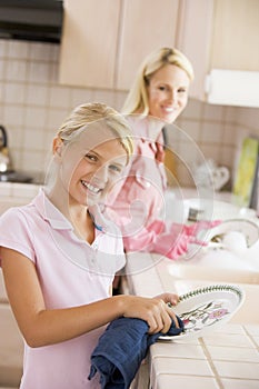 Mother And Daughter Cleaning Dishes