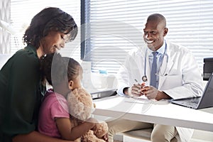 Mother And Daughter In Consultation With Doctor In Office