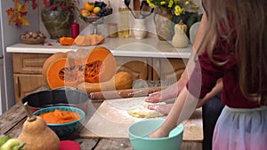 Mother and daughter cook pumpkin pie at home. Cooking together for a festive Thanksgiving dinner. A farmer's family