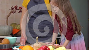 Mother and daughter cook pumpkin pie at home. Cooking together for a festive Thanksgiving dinner. A farmer's family