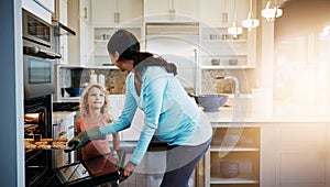 Mother, daughter and cookies in oven for baking in kitchen with learning, bonding and fun in home with sunlight. Family