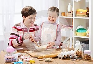 Mother and daughter cooking and having fun, home kitchen interior, healthy food concept