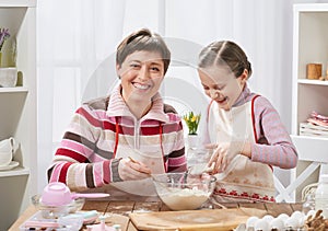 Mother and daughter cooking and having fun, home kitchen interior, healthy food concept