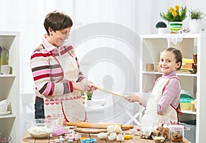 Mother and daughter cooking at home, making the dough for buns