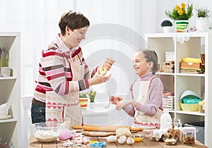 Mother and daughter cooking at home, making the dough for buns