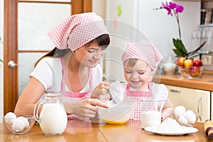 Mother and daughter cooking together at kitchen