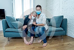 Mother and daughter crying at home in quarantine grieving loss of family members amid COVID-19