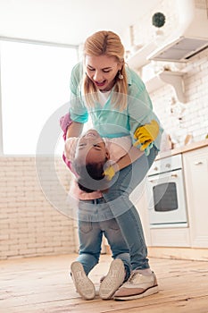 Mother and daughter dancing in the kitchen after cleaning the flat