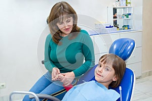 A mother with a daughter in a dentistÃ¢â¬â¢s office. Medicine, dentistry and health care photo