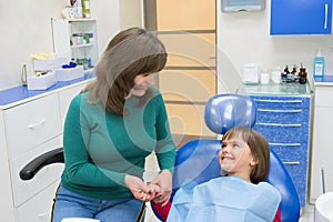 A mother with a daughter in a dentistÃ¢â¬â¢s office. Medicine, dentistry and health care photo