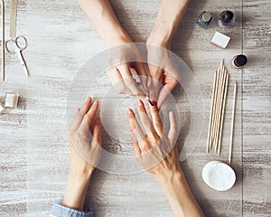 Mother and daughter do manicure, paint nails with varnish. Home self-care during quarantine