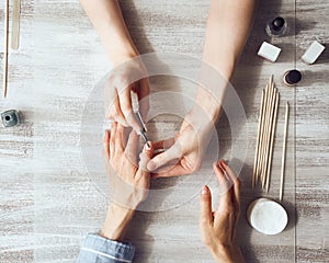 Mother and daughter do manicure, paint nails with varnish. Home self-care during quarantine