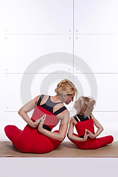 Mother and daughter doing yoga exercise, fitness, gym sports paired