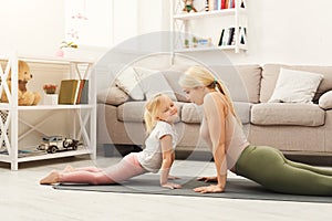 Mother and daughter doing yoga exercises at home