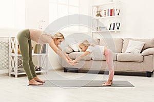 Mother and daughter doing yoga exercises at home