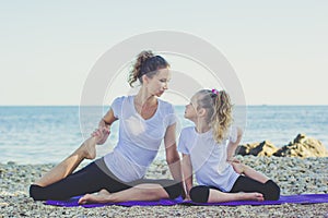 Mother and daughter doing yoga outdoors