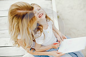 Mother with daughter drawing in a park