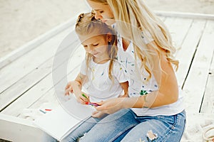 Mother with daughter drawing in a park