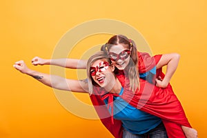 Mother and daughter dressed like superheros flying off to save the world from villans