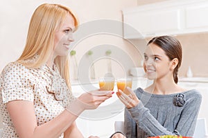 Mother and daughter drink juice