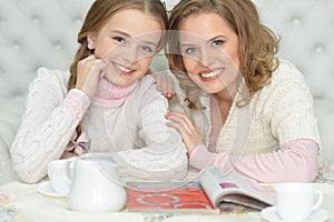 Mother and daughter drinking tea at home