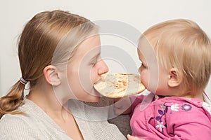 Mother with daughter eat and bitting flatbread