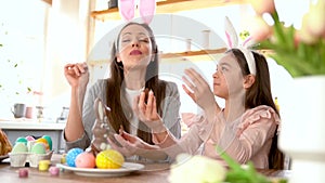 Mother, daughter eating delicious chocolate eggs