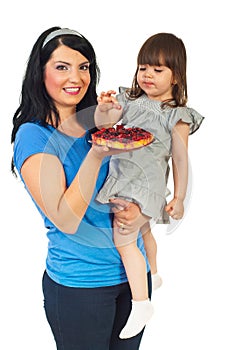 Mother with daughter eating fruit tart